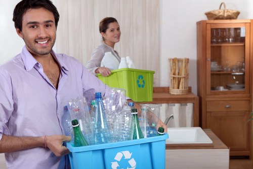 Workers sorting recyclables from a skip at a local transfer station